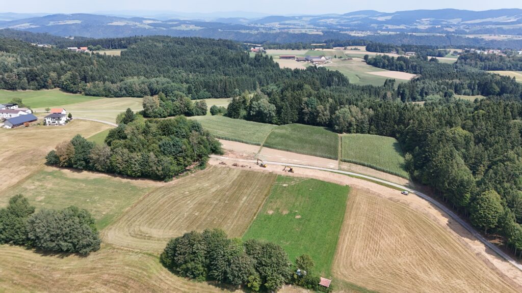 Luftaufnahme des Baufortschritts am Agrarweg Reiting-Kiriau mit Baufahrzeugen im Bereich der neuen Trasse