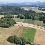 Luftaufnahme des Baufortschritts am Agrarweg Reiting-Kiriau mit Baufahrzeugen im Bereich der neuen Trasse