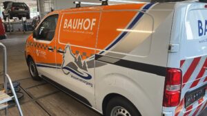 Heckansicht des folierten Bauhof-Fahrzeugs mit rot-weißer Warnmarkierung