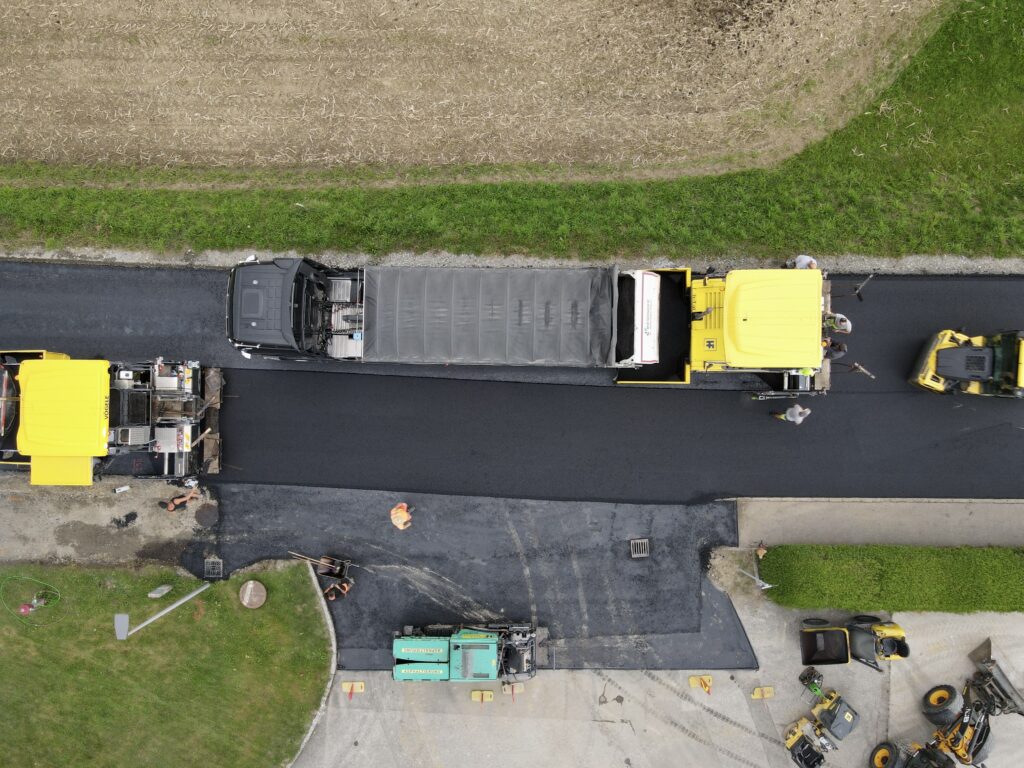 Senkrechte Drohnenaufnahme der neu asphaltierten L 517 Keßla Straße im Kreuzungsbereich mit Fertigern, Lkw und Walzen