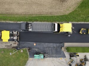 Senkrechte Drohnenaufnahme der neu asphaltierten L 517 Keßla Straße im Kreuzungsbereich mit Fertigern, Lkw und Walzen