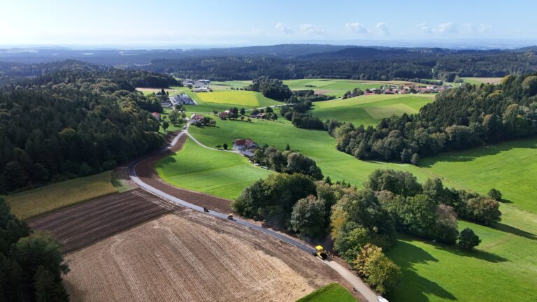 Drohnenaufnahme des Agrarweges Reiting-Kiriau während der Asphaltierung, Asphaltfertiger und zwei Walzen auf der neuen Fahrbahn