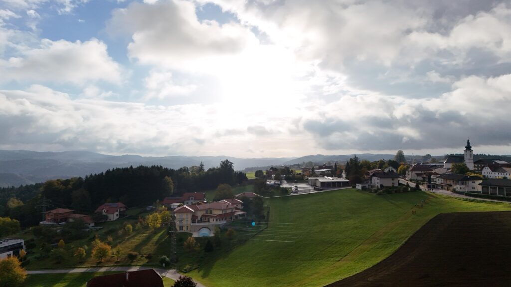 Luftaufnahme von St. Aegidi mit Pfarrkirche, Wiesen und Blick über den Sauwald im Herbst