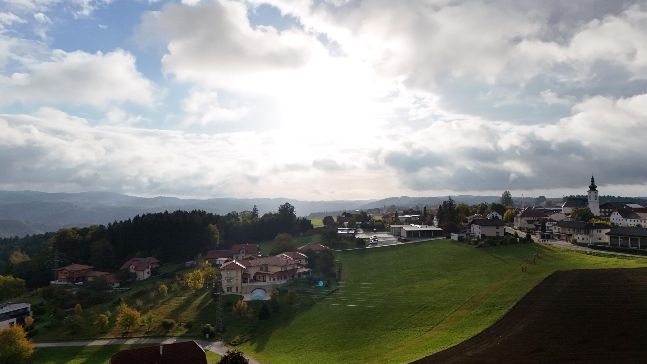 Luftaufnahme von St. Aegidi mit Pfarrkirche, Wiesen und Blick über den Sauwald im Herbst